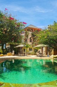 a pool surrounded by lush green trees next to a building