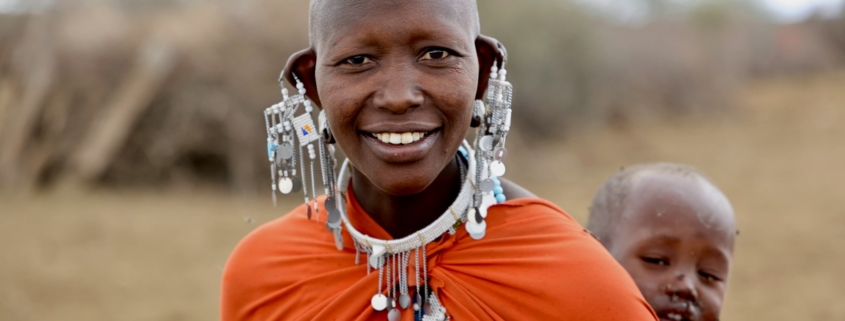 a woman smiling with a man behind her