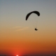 silhouette of person riding parachute during sunset