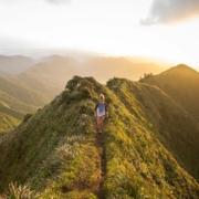 woman walking on pathway on top of hill at golden hour